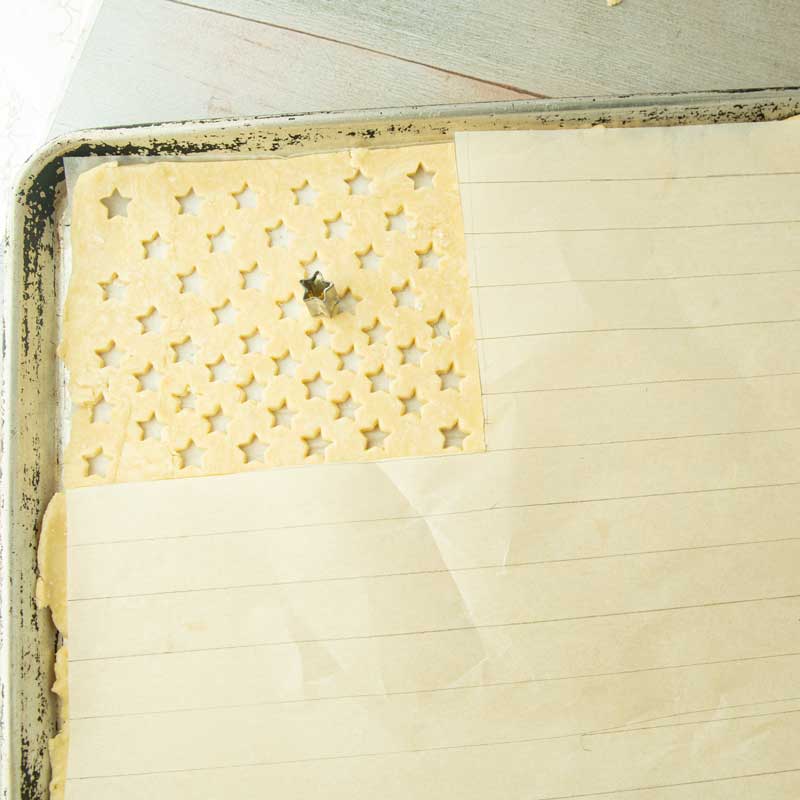stripes drawn on parchment next to stars cut on pastry dough