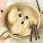 closeup of coffee ice cream in beige cup with chocolate Pocky sticks