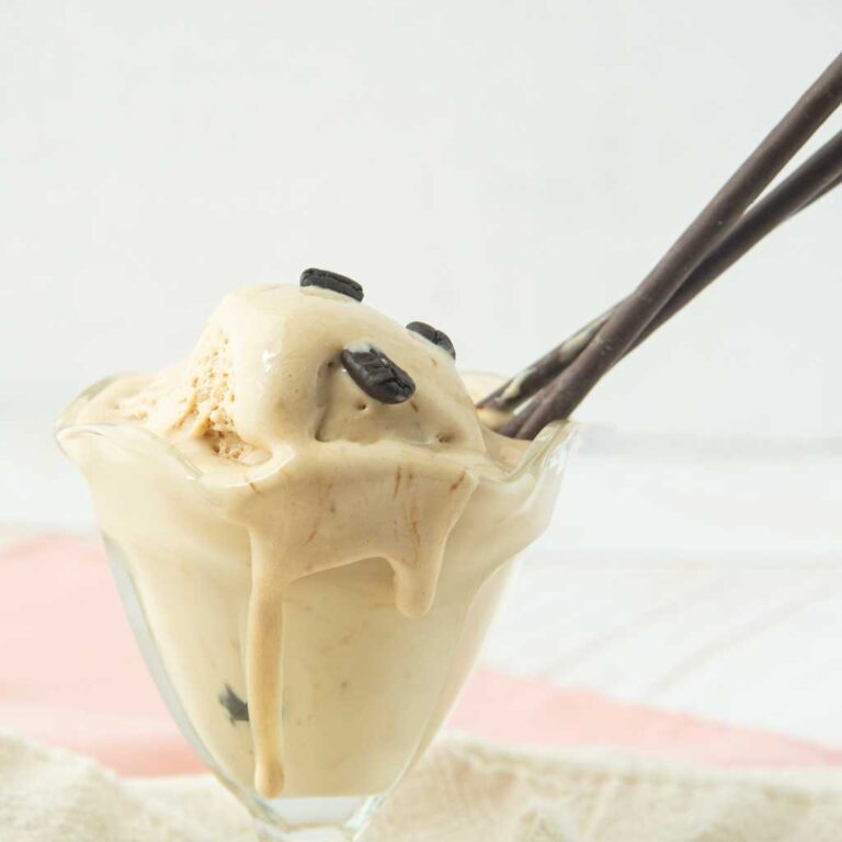 coffee ice cream in glass dish topped with coffee beans and chocolate Pocky sticks