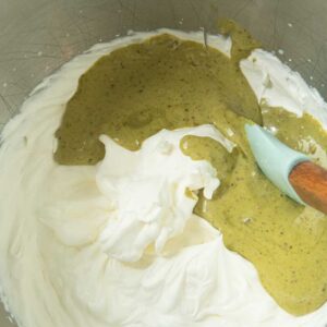 adding pistachio cream to heavy cream