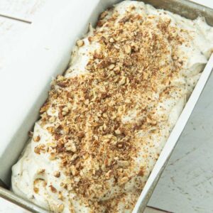 butter pecan ice cream in loaf pan topped with chopped candied pecans