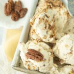 closeup of scoops of butter pecan ice cream with whole candied pecans