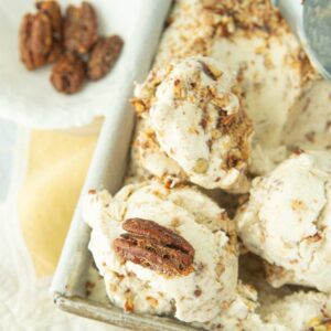 closeup of scoops of butter pecan ice cream with whole candied pecans
