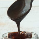 fudge sauce dripping into jar from spoon, text overlay