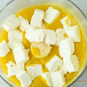 chunks of cream cheese added to mango puree in food processor