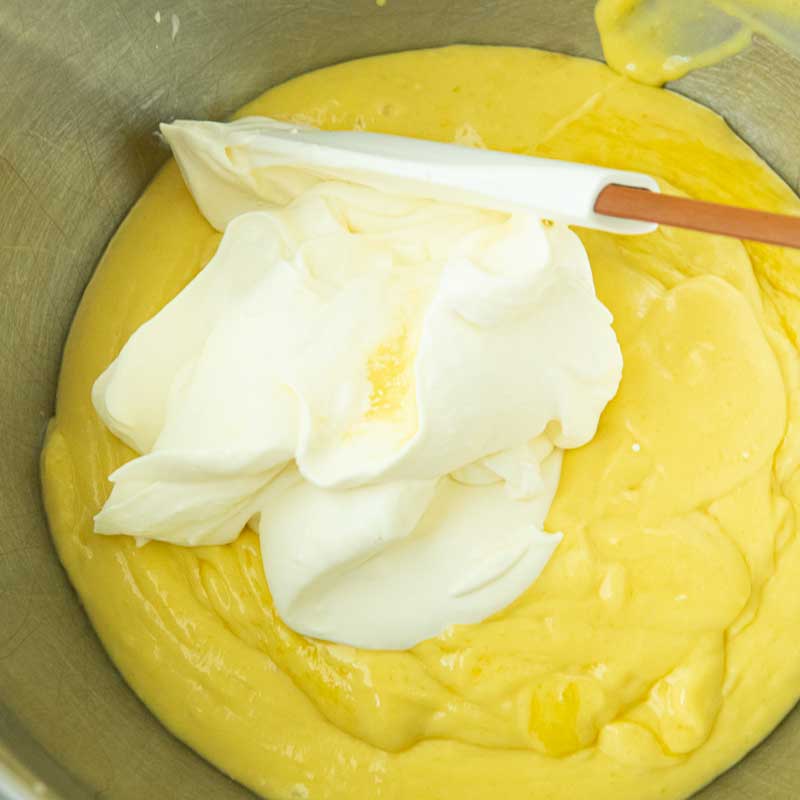 folding mango puree and whipped cream together with spatula