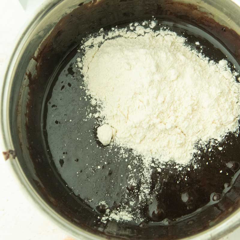 adding flour to brownie batter