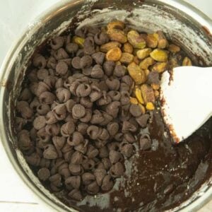 folding chocolate chips and pistachios into brownie batter