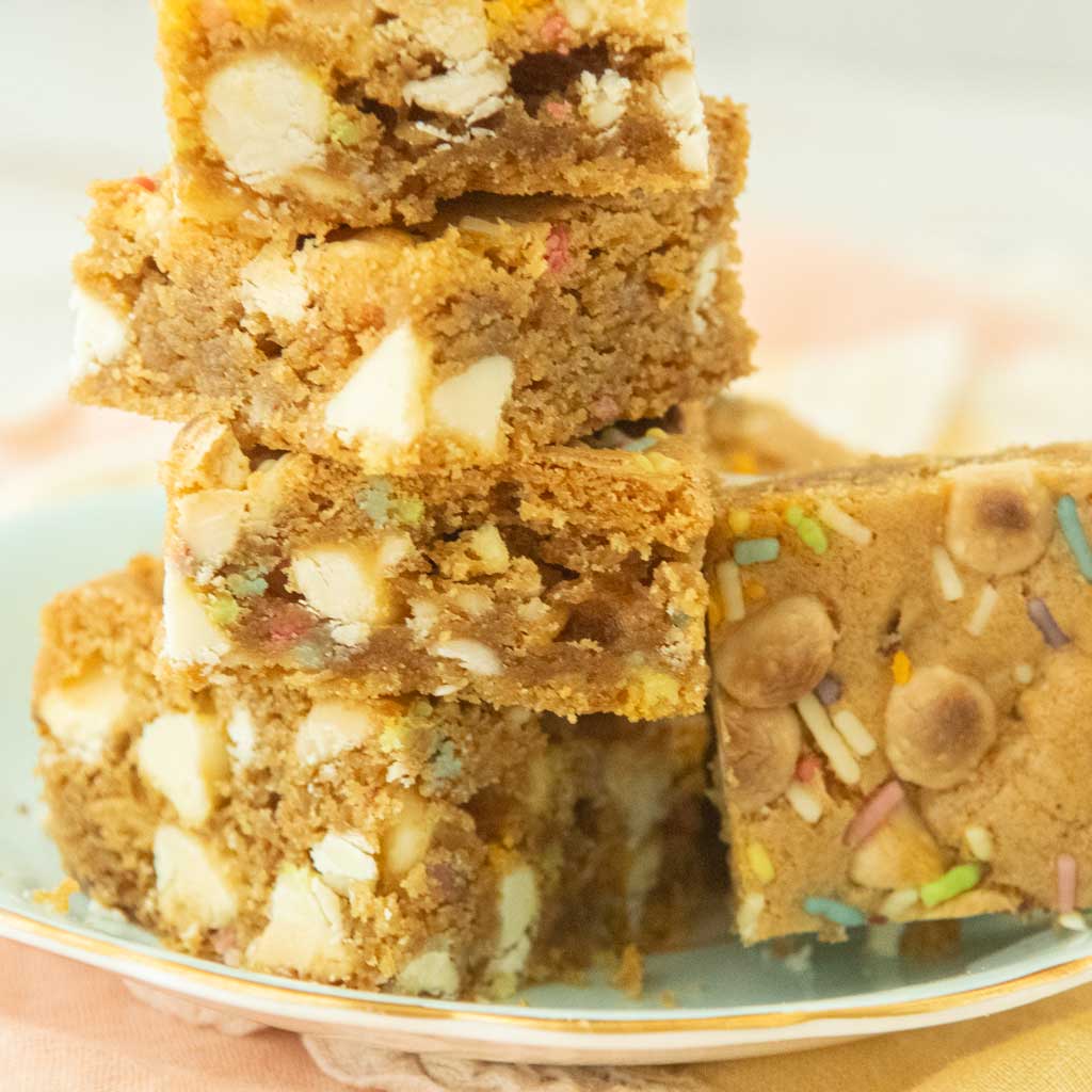 cross section closeup of brown butter birthday cake blondies showing white chocolate chips and sprinkles