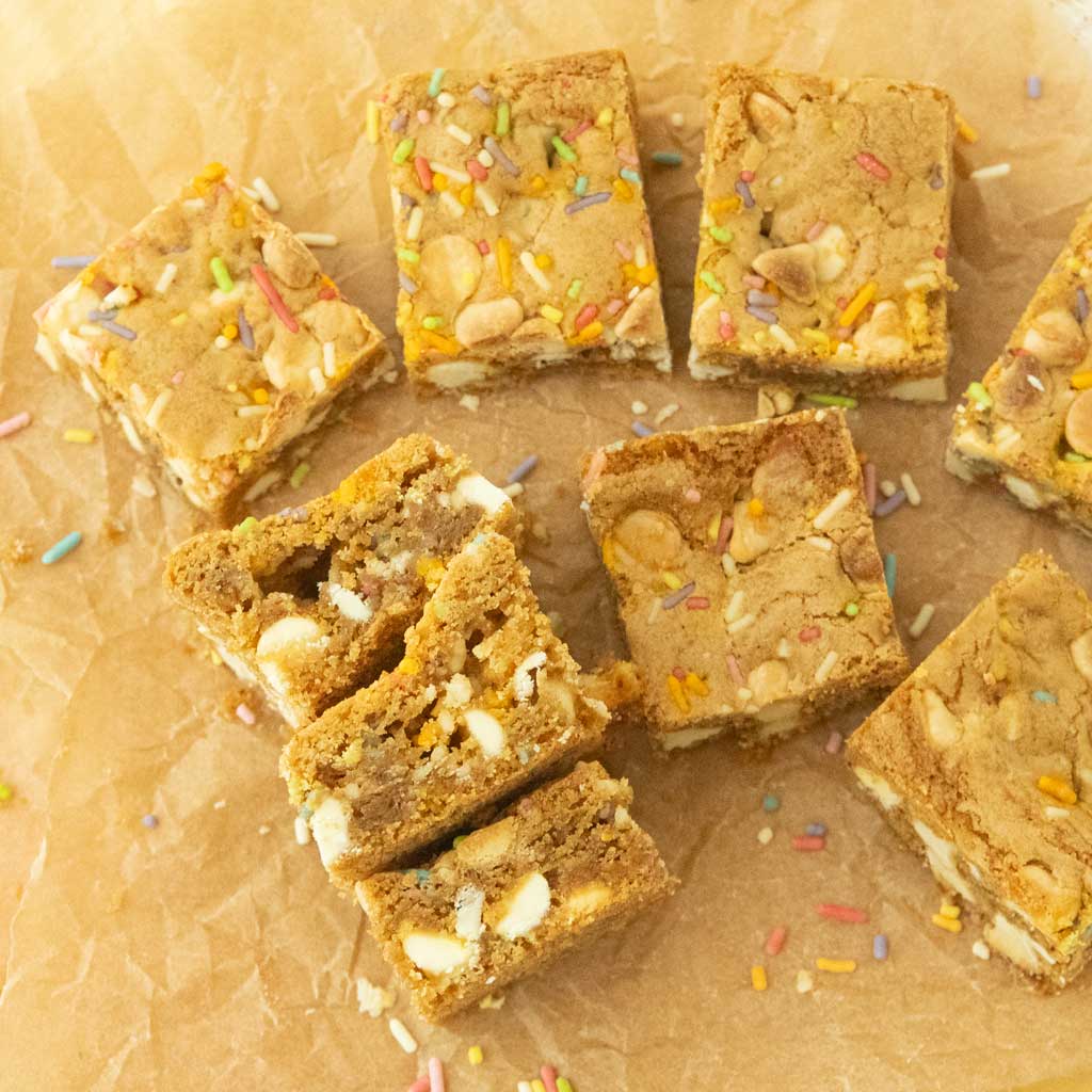 cut pieces of birthday cake blondies on brown paper