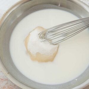 whisking flour, sugar, and milk in skillet for roux frosting