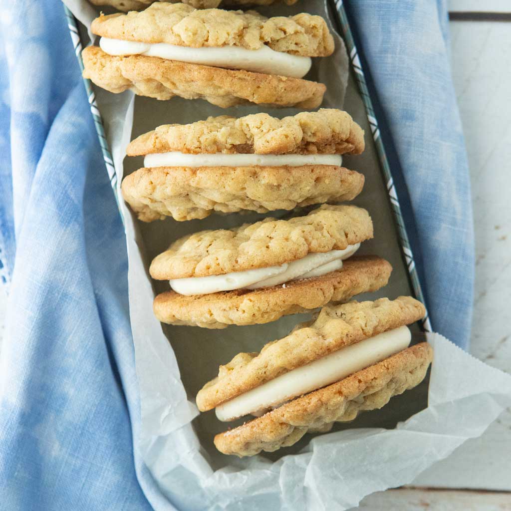oatmeal cream pies in tin lined with parchment on blue napkin