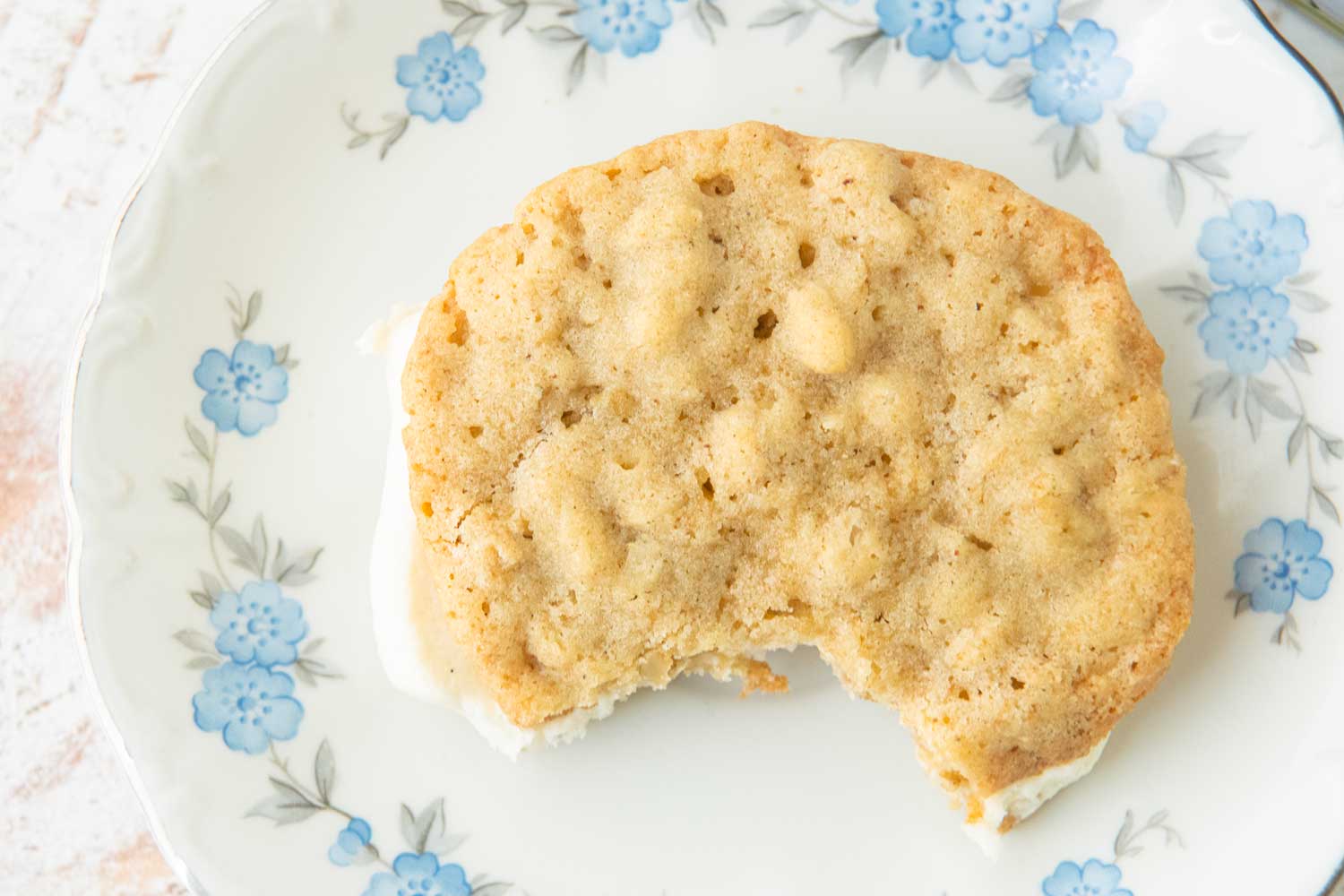 oatmeal cream pie with bite out of it on white plate with blue flowers