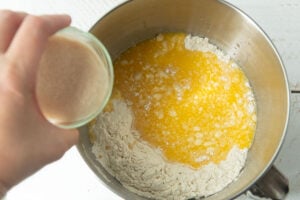 adding yeast water to flour and milk and eggs for rolls