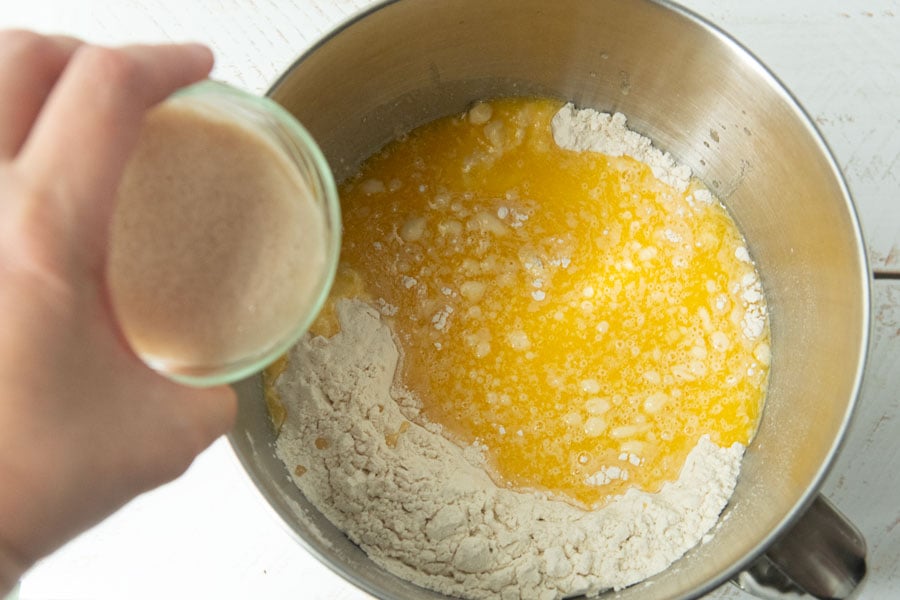 adding yeast water to flour and milk and eggs for rolls