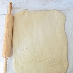 dough rolled on pastry cloth, rolling pin