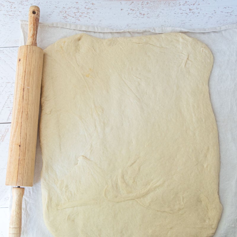 dough rolled on pastry cloth, rolling pin