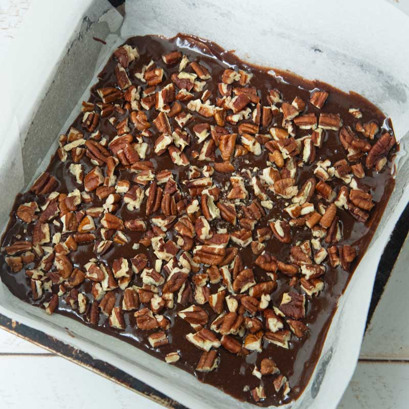 chopped pecans over brownie batter in pan