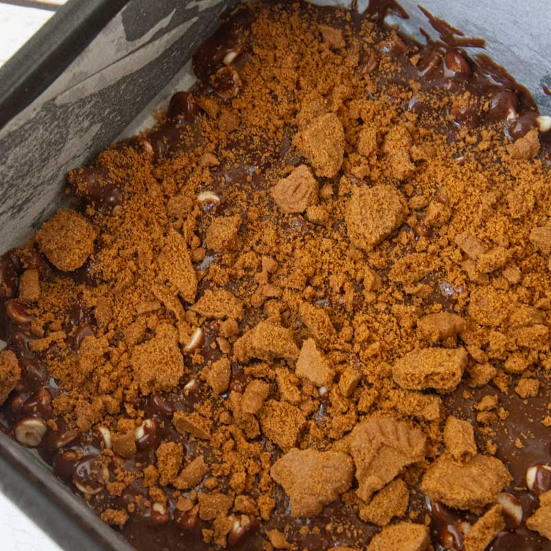 crushed biscoff ookies on brownie batter