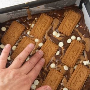 pressing biscott cookies onto top of brownie batter