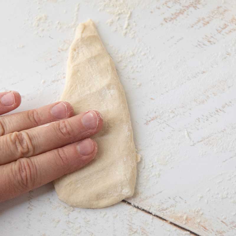 patting dough into triangle