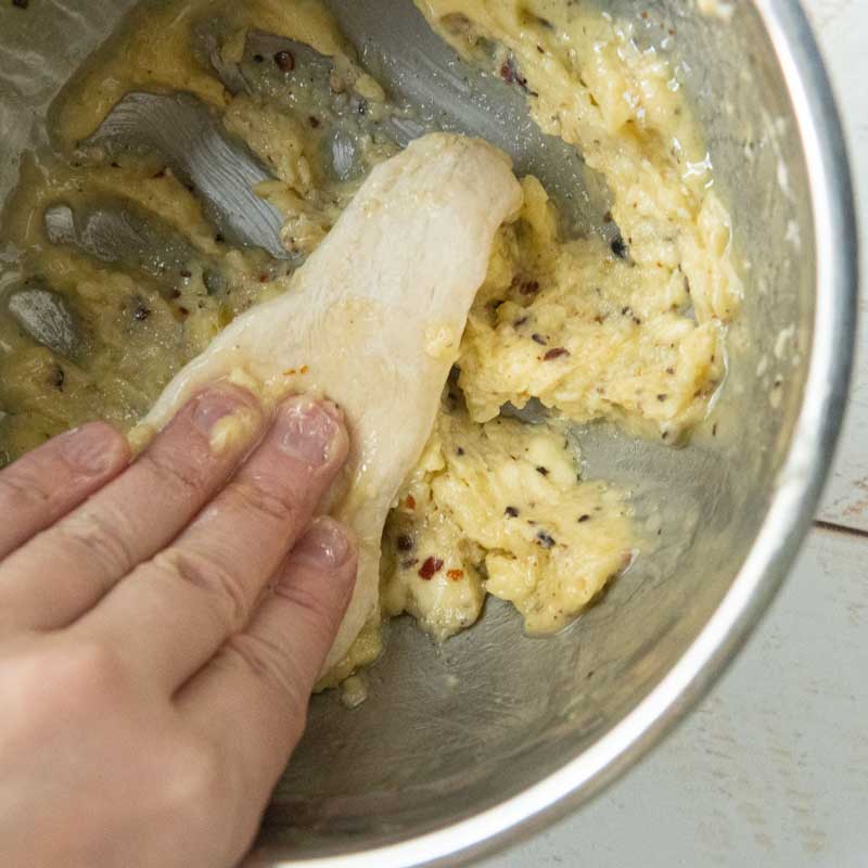 dipping bread dough into garlic butter