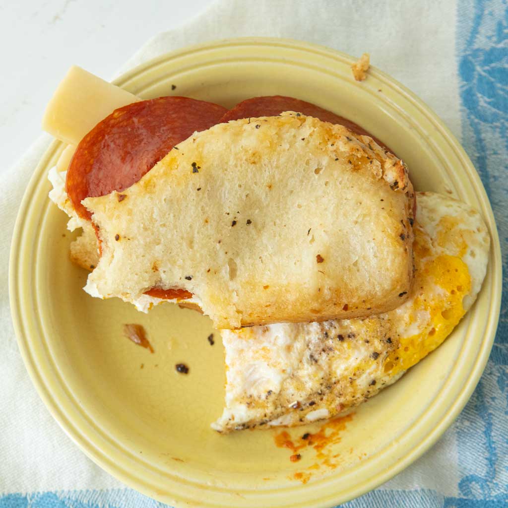 breakfast sandwich made with salami, fried egg, cheese, and pull apart garlic bread