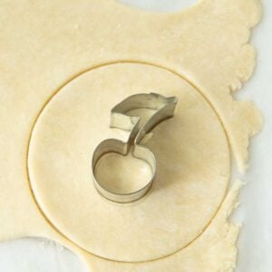 mini cherry cookie cutter on top of dough round