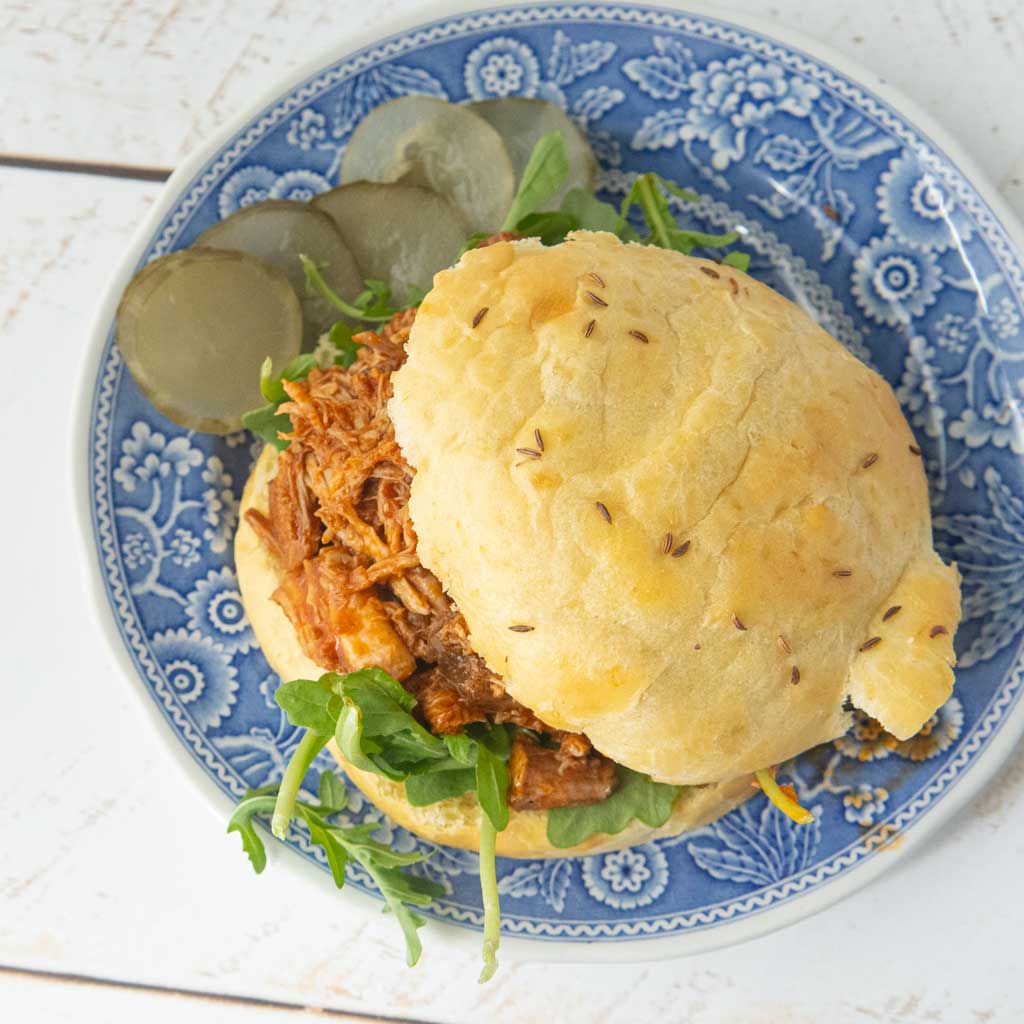 pulled pork, pickles on potato bun with arugula