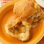 piece of apple monkey bread cut open to show apple filling and a piece of whole apple monkey bread