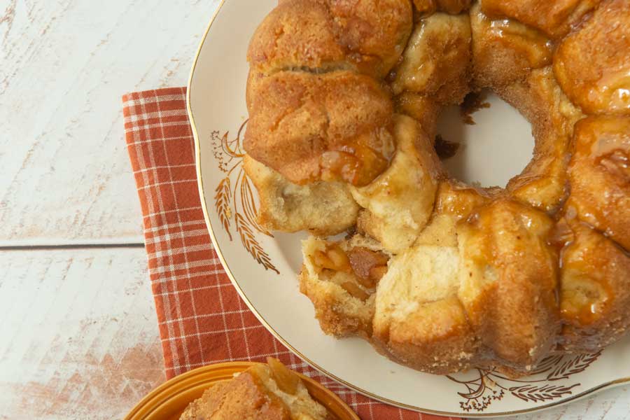 close up of apple monkey bread on plate with pieces pulled off of it